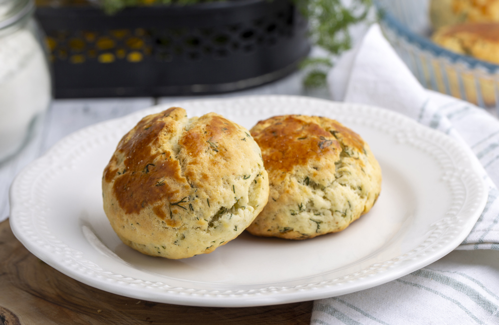 Beyaz bir tabağın üstünde 2 adet dereotlu poğaça.