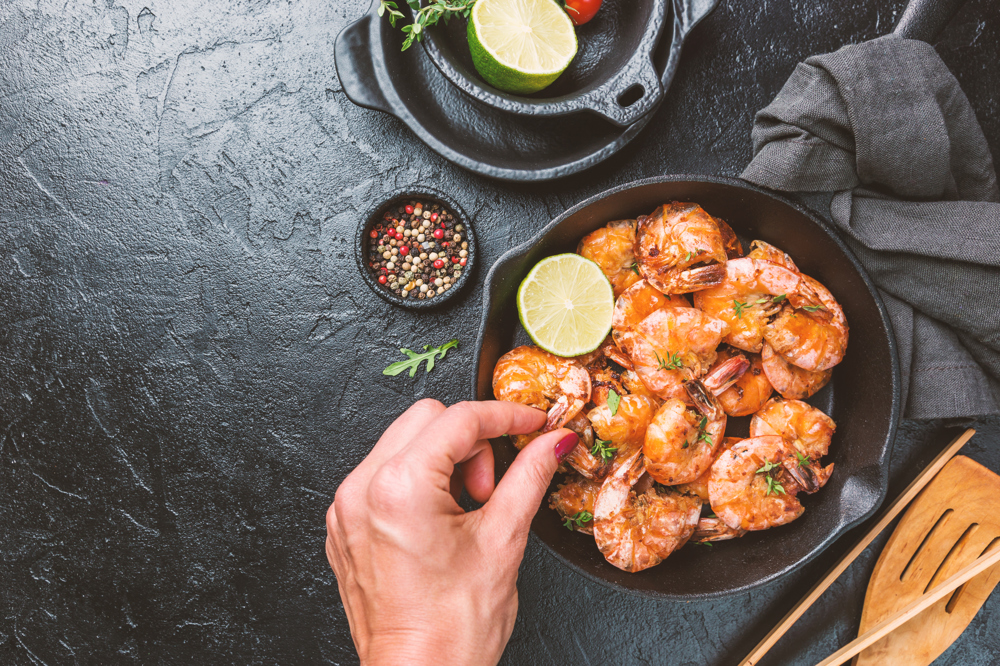 1 Yemek tabağı karides ve dilimenmiş limonlar.