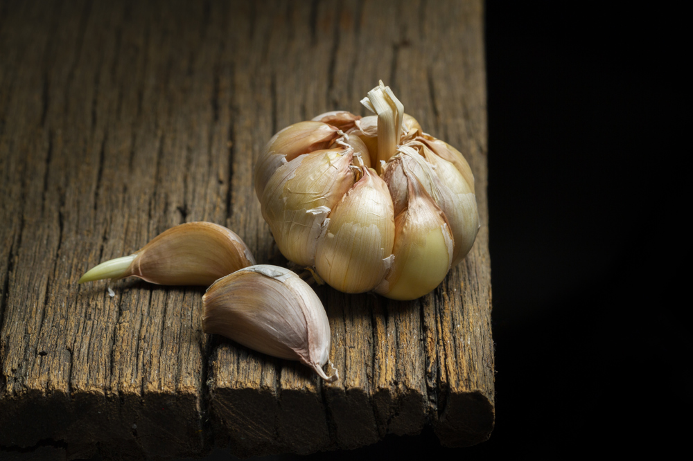 Yarısı soyulmuş, 2 dişi ayıklanmış sarımsak.