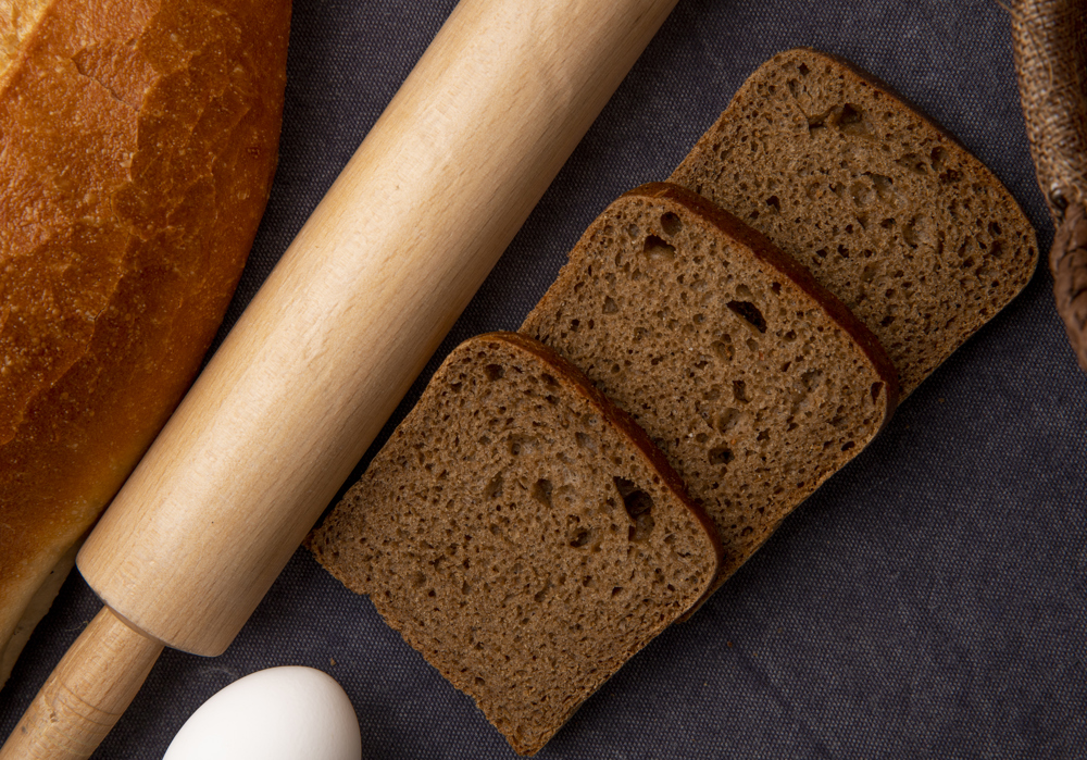 Masanın üzerinde dilimlenmiş tam buğday ekmekleri kare kare.